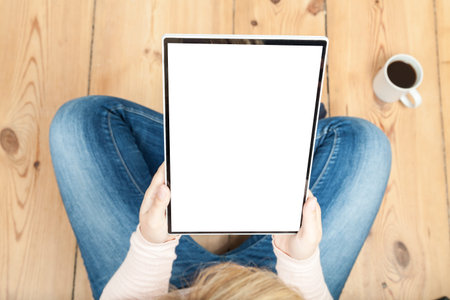 woman reading on tablet with wooden floor