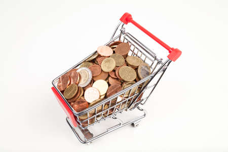 shopping cart with coins on whiteの写真素材