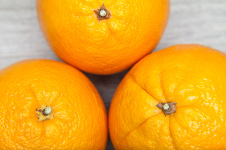 three oranges on grey tableの写真素材