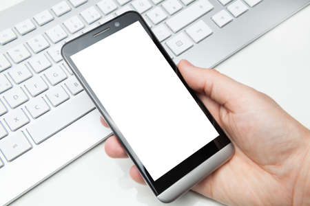 smartphone holding in hand in officeの写真素材