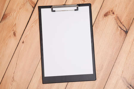 clipboard with white sheet on wooden floorの写真素材