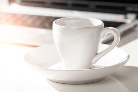 cup of espresso and laptop on deskの写真素材