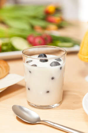 huckleberry yogurt with spoon on breakfast tableの写真素材