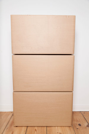stack of moving boxes on wooden floor