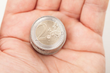 Two Euro coins in hand