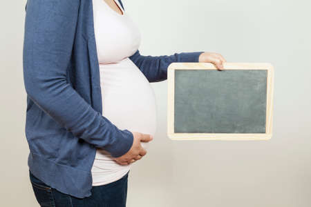 Pregnant woman holding a blackboardの写真素材