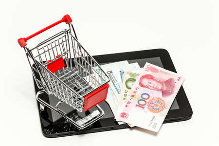 Yuan banknots, tablet computer and shopping cart (symbol photo)の写真素材
