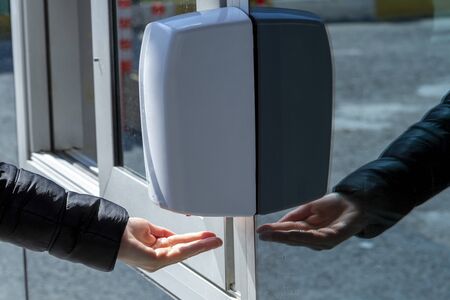 Hand using alcohol gel disinfecting handsの写真素材