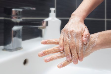 Woman washing hands with soap. An unrecognizable female showing how to wash hands properly....