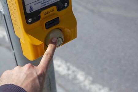 Hand pressing a button at traffic lightsの写真素材