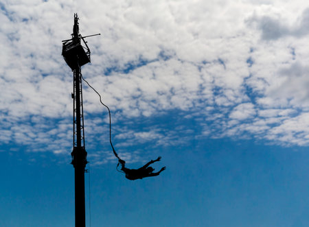 bungee jumping on fluffy clouds in the blue sky