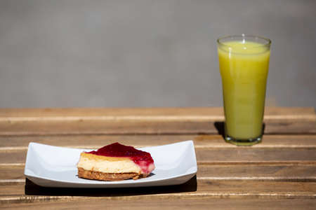close up raspberry cheesecake and lemonade on wooden tableの写真素材