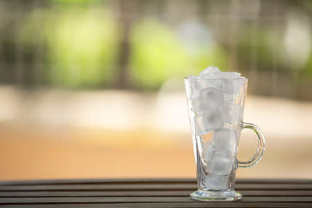 Closeup one glass with ice  on wooden table. Selective focusの写真素材