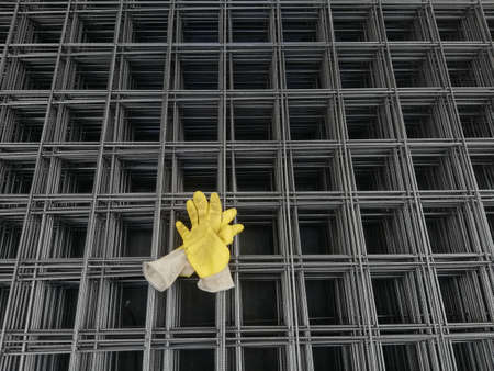 Yellow gloves standing on iron backgroundの写真素材