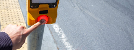 Hand pressing a button at traffic lights