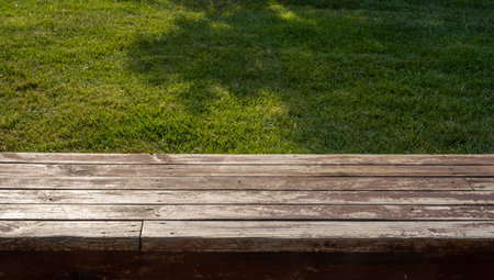 empty wooden floor in front of grass background
