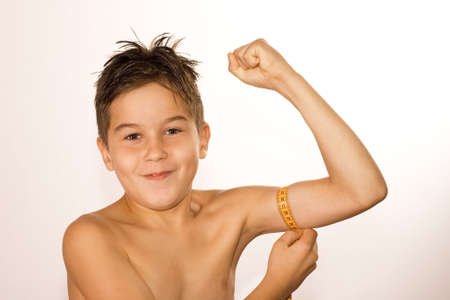 Little boy takes his measurements and smiles with the resultsの写真素材