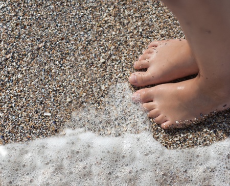Two child feet on the beachの写真素材