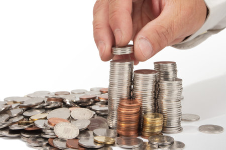 Human hand rising coins - isolated in white