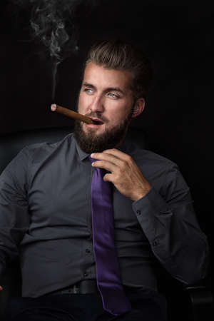 Young businessman smoking a cigarの写真素材