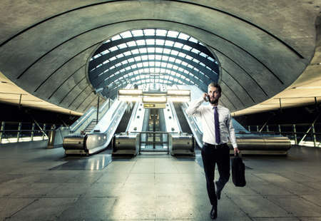 Business man is talking on the phone while he is walking through the hallの写真素材