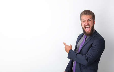Crazy business man is pointing his finger on a white boardの写真素材