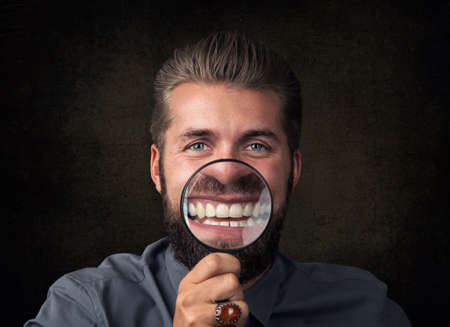 Young man having fun with magnifying glassの写真素材