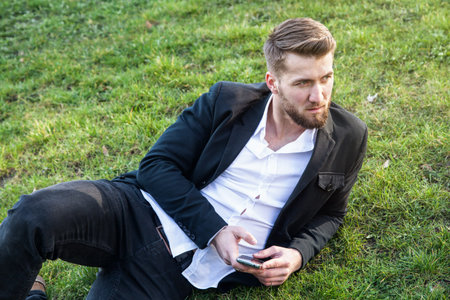 Attractive business man is having a rest in a parkの写真素材