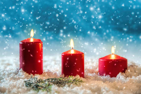3 candles in the snowの写真素材