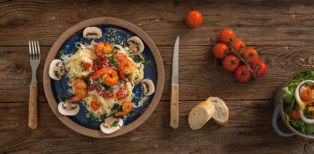 A delicious plate of shrimp scampi on spaghetti, tomatoes and breadの写真素材