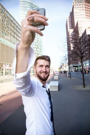 Young attractive businessman makes a selfie with a smartphoneの写真素材