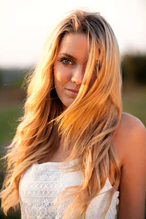 Portrait of a young woman with blond hair at sunsetの写真素材