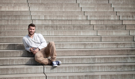 Attractive man is sitting on stepsの写真素材