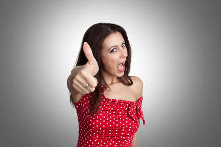Beautiful happy woman is showing her thumb upの写真素材