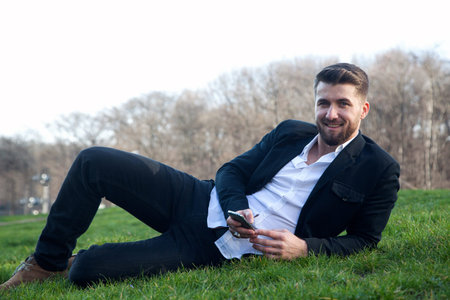 Attractive business man is having a rest in a parkの写真素材