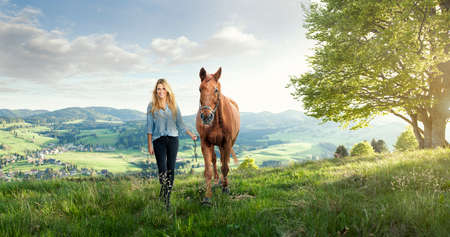 Beautiful girl with a horse in the german mountainsの写真素材