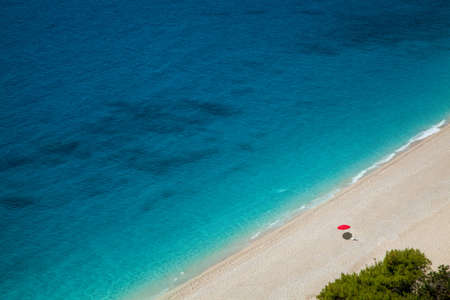 Beautiful beach and one red parasolの写真素材