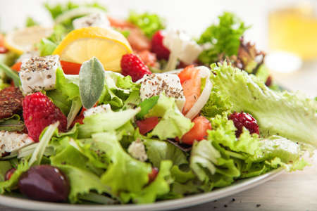 Summer salad with green lettuce and a lemonの写真素材