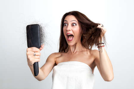 Beautiful woman is screaming because she recognized her hair lossの写真素材