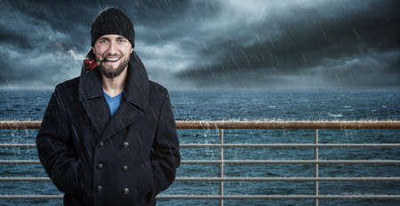 Attractive seafarer on his ship in bad weatherの写真素材