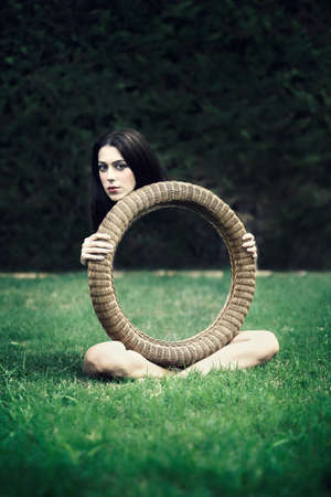 An illusion, beautiful girl with a mirror in her handsの写真素材