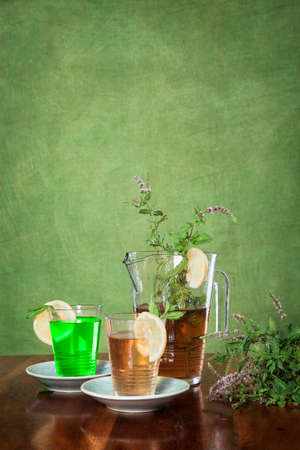 Homemade ice tea with lemon on a green backgroundの写真素材
