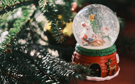 Closeup of Snow Globe With Snow Flakes and Santa, Beautiful Holiday Concept with Christmas treeの写真素材