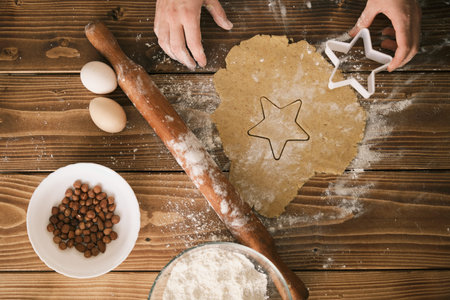 Preparation of shaped cookies from raw dough on the wooden board. top-view