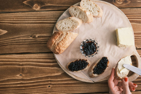 Sturgeon black caviar on a wooden board with butter