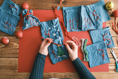 Fabric bags for Christmas gifts and handmade numbers with decorations on the table. Hand made Advent...