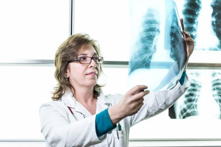 Female doctor holding and checking xray image of lungs.の写真素材