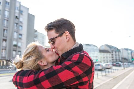 Young stylish pretty couple kissng and having fun outdoors on a date. Blurred backgroundの写真素材