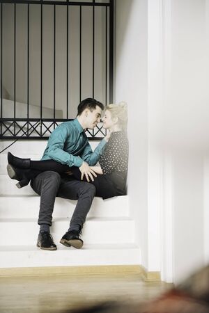 Passionate kiss of a couple in their luxurious home. Foreground is blurredの写真素材