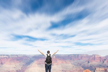 Young man enjoying the view with spreaded handsの写真素材
